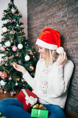 Güzel sarışın genç kadın yanındaki Noel ağacı rahatlatıcı.