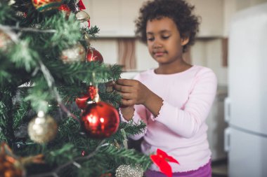 küçük kız Noel ağacı süsleme. Doğal ışık