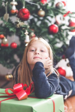 Güzel kızıl saçlı Hediyelik Noel ağacı önünde küçük kız. Doğal ışık. 