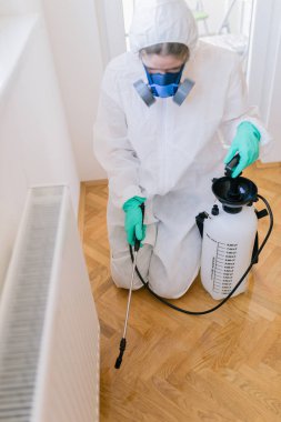 İşteki ilaçlamacı ilaçlama için sprey sıkar.