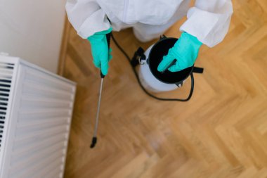 İşteki ilaçlamacı ilaçlama için sprey sıkar.