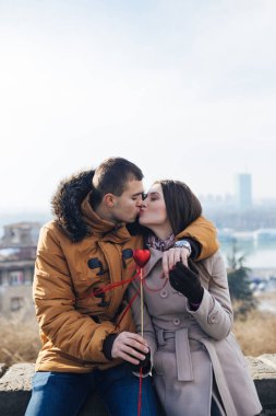 Güzel genç çift, bir kalp kız arkadaşına veren adam sarılma ve birlikte zevk aşık