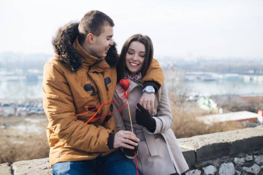 Güzel genç çift, bir kalp kız arkadaşına veren adam sarılma ve birlikte zevk aşık