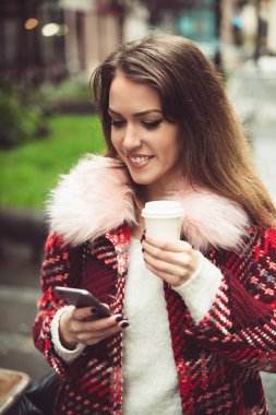 Kahve street, cep telefonuyla mesaj üzerinde yürüme ile moda güzel genç kadın