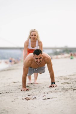Plajda eğlenmek ve bazı fitness egzersiz yapıyor genç çekici insanların Grubu.