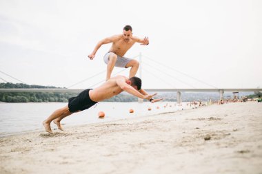 Plajda eğlenmek ve bazı fitness egzersiz yapıyor genç çekici insanların Grubu.