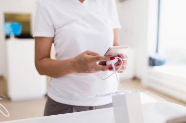 Güzel kadın alışveriş. Mobil olarak duruyor ve dükkanı ve seçimi bir sonraki model onun için tablet