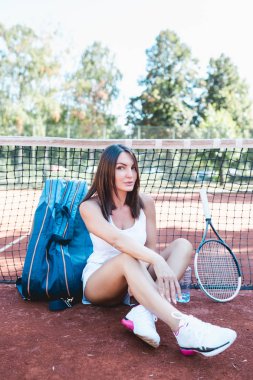 Güzel genç kadın rahatlatıcı tenis kortunda onu tenis maçı sonrası.
