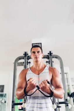 Spor salonunda ağırlık çekici bir genç adam. Fitness, spor ve sağlık kavramı