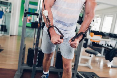Spor salonunda ağırlık çekici bir genç adam. Fitness, spor ve sağlık kavramı