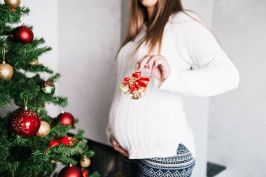 Noel ağacı yanında oturan ve tatil zevk hamile kadın. 