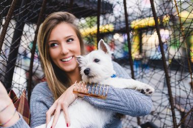 Güzel genç kadın selfie fotoğraf sevimli westie köpek yavrusu alarak.