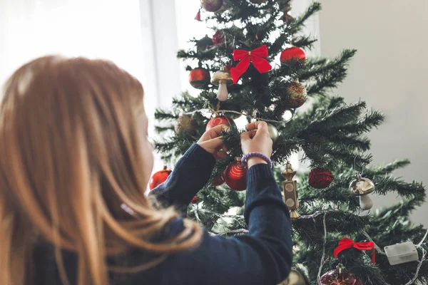 küçük kız Noel ağacı süsleme. Doğal ışık