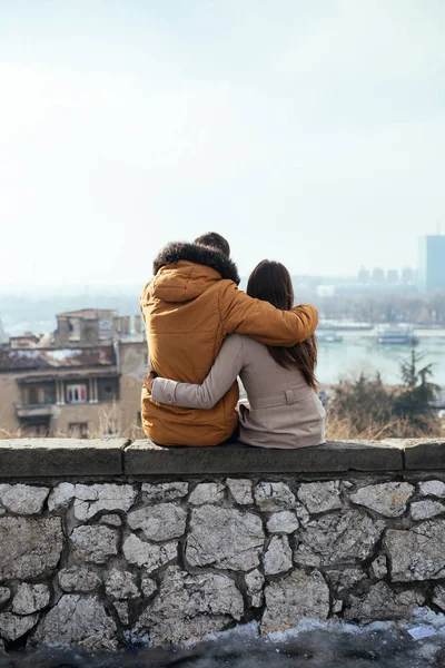Birlikte, duvar kenarında oturan ve güzel görünümde zevk zevk aşık güzel genç çift