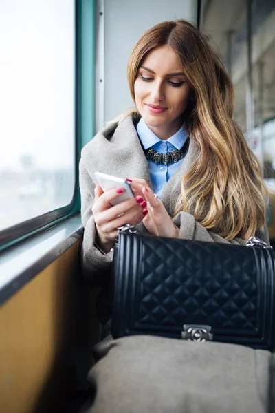 市バスで座って携帯電話を見て美しいの若い女性 — ストック写真