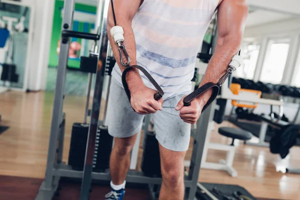 Spor salonunda ağırlık çekici bir genç adam. Fitness, spor ve sağlık kavramı