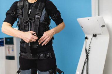 Güzel kadın kıdemli elektrik Kas stimülasyonu elbiseli egzersizleri yapıyor.