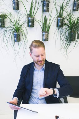 Onun ofisinde oturuyor ve onun bakarak kendine güvenen genç redhead iş adamı.