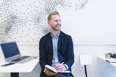 Kızıl saçlı iş adamı bir şey onun not defterinde yazıyor