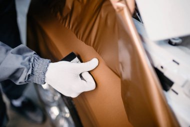 Araba ambalaj uzmanı arabaya vinil folyo ya da film koyuyor. Seçici odak.