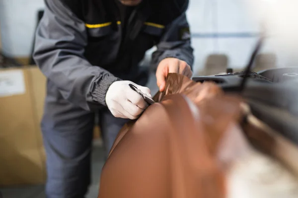 Araba ambalaj uzmanı arabaya vinil folyo ya da film koyuyor. Seçici odak.