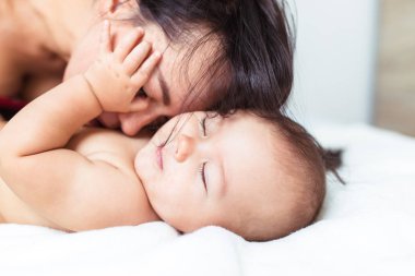 Onun şirin bebek yatakta ile rahatlatıcı ve zevk güzel annem.