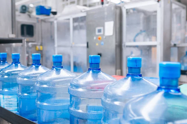 瓶装水厂 处理纯泉水并将其装瓶成蓝色瓶子的瓶装水生产线有选择的重点 — 图库照片