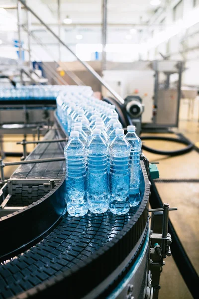 Bottling plant - Water bottling line for processing and bottling pure spring water into blue bottles. Selective focus.