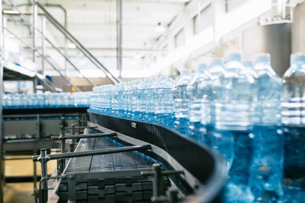 瓶詰め工場 純泉水をブルーボトルに加工および瓶詰めするための水ボトリングライン 選択的焦点 — ストック写真