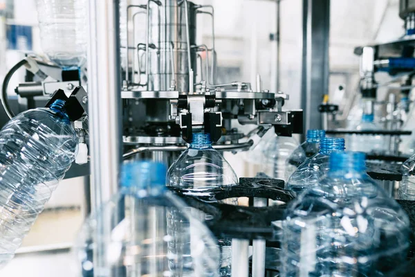 Bottling plant - Water bottling line for processing and bottling pure spring water into blue bottles. Selective focus.