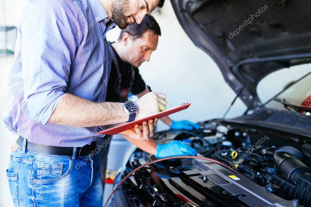 Auto mechanics repairing car. 