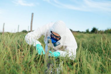 Tarım ilaçlama - koruyucu iş genç işçi giymek kontrol meyve plantasyon büyüyen.