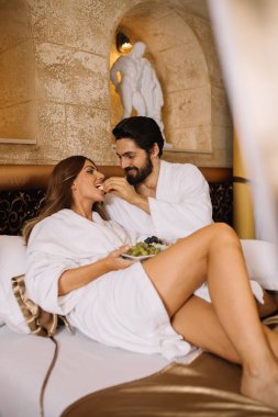 Güzel genç çift zevk ve Spa merkezinde rahatlatıcı ve meyve yatakta kahvaltı