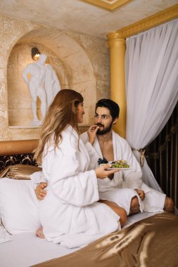 Güzel genç çift zevk ve Spa merkezinde rahatlatıcı ve meyve yatakta kahvaltı
