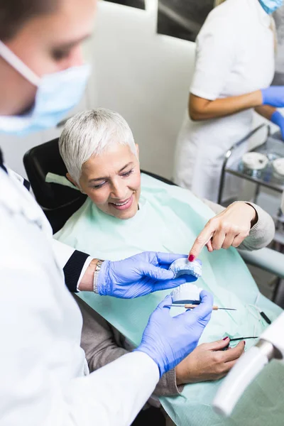 Beautiful senior woman at dentist having dental treatment at dentist\'s office.