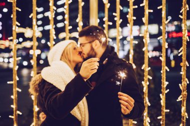Aşık güzel genç çift bir şehir sokakta Noel veya Yeni Yıl gecesi zevk. 