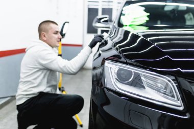 Araba temizleme - Oto tamir atölyesinde orbital cilası olan bir işçi