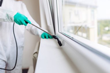 İşteki ilaçlamacı ilaçlama için sprey sıkar..