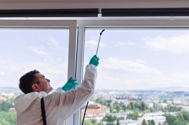 İşteki ilaçlamacı ilaçlama için sprey sıkar..