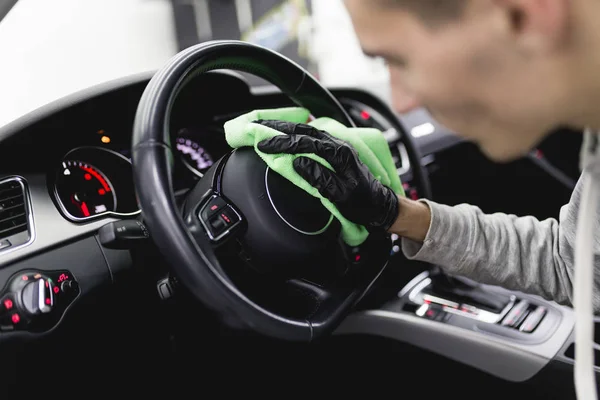 man cleaning car interior, car detailing (or valeting) concept. Selective focus
