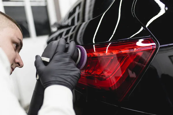 Car detailing - Worker with orbital polisher in auto repair shop