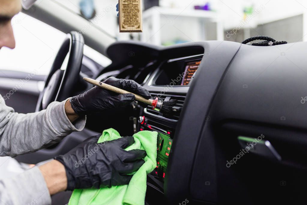man cleaning car interior, car detailing (or valeting) concept. Selective focus
