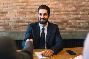 İş toplantısı. Yakışıklı genç adam başarılı iş görüşmesi sonrası sallayarak.