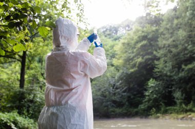 Koruyucu süitteki bilim adamları nehirden su örnekleri alıyorlar..