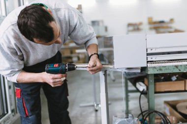Alüminyum ve Pvc pencere ve kapı üretimi için fabrika. Pvc kapı ve pencereleri monte eden el işçisi. Seçici odaklama. 