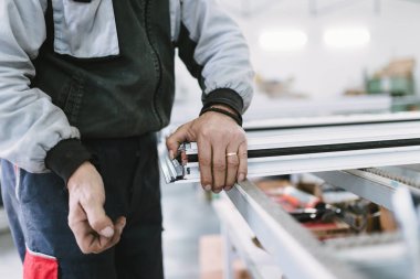 Alüminyum ve Pvc pencere ve kapı üretimi için fabrika. Pvc kapı ve pencereleri monte eden el işçisi. Seçici odaklama. 