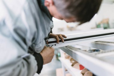 Alüminyum ve Pvc pencere ve kapı üretimi için fabrika. Pvc kapı ve pencereleri monte eden el işçisi. Seçici odaklama. 