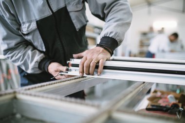 Alüminyum ve Pvc pencere ve kapı üretimi için fabrika. Pvc kapı ve pencereleri monte eden el işçisi. Seçici odaklama. 