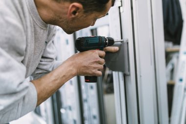 Alüminyum ve Pvc pencere ve kapı üretimi için fabrika. Pvc kapı ve pencereleri monte eden el işçisi. Seçici odaklama. 