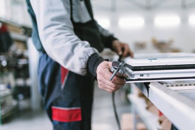 Alüminyum ve Pvc pencere ve kapı üretimi için fabrika. Pvc kapı ve pencereleri monte eden el işçisi. Seçici odaklama. 